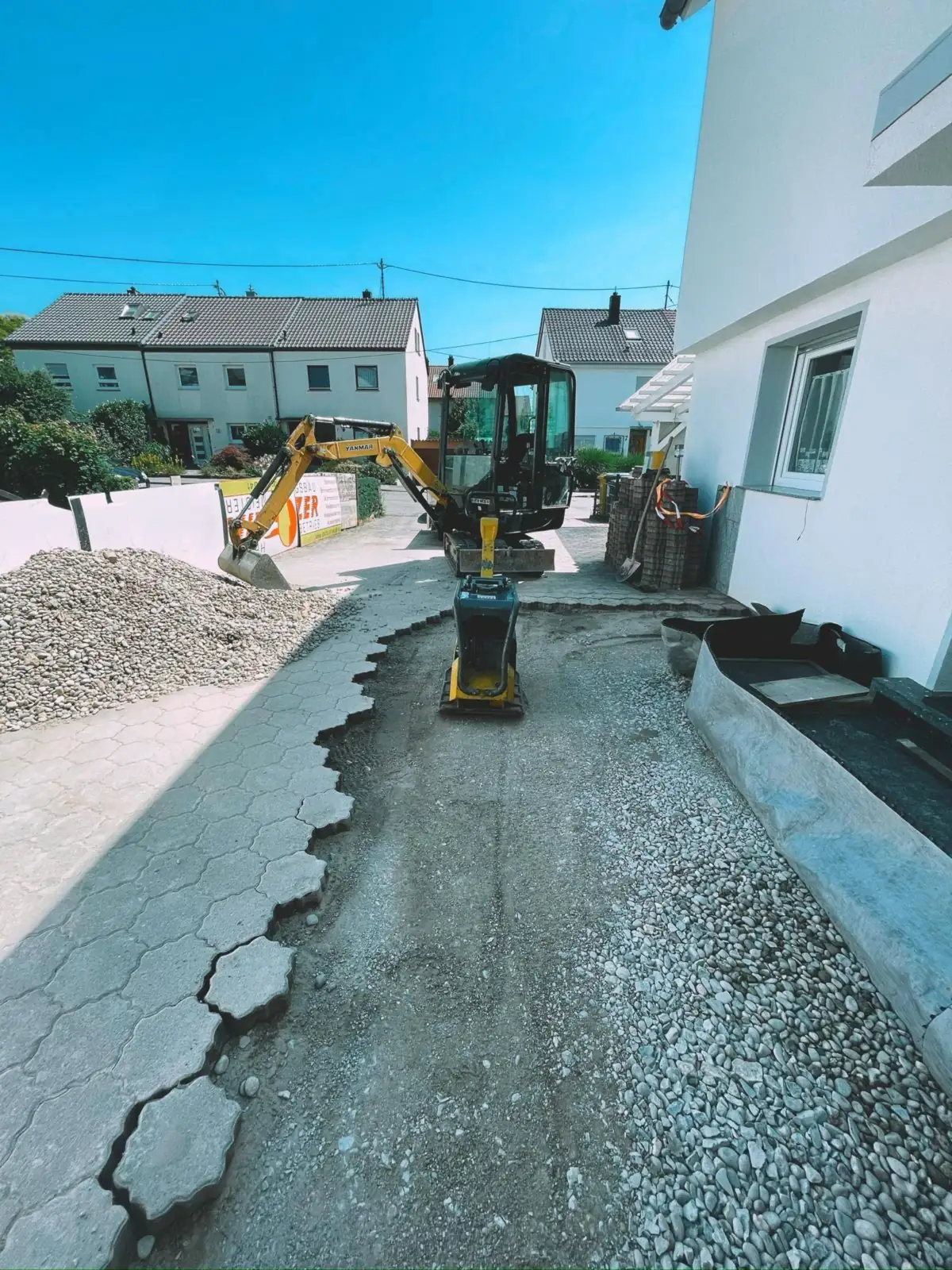 Minibagger auf einer Baustelle an einer Hofeinfahrt