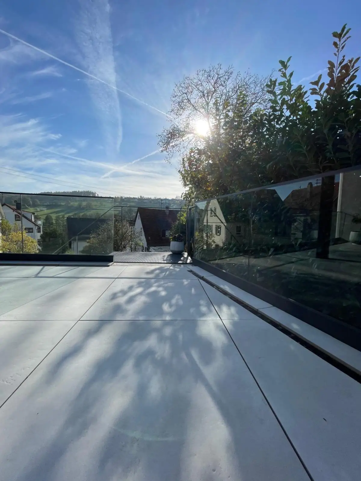 Terrasse mit Glasgeländer in der Morgensonne