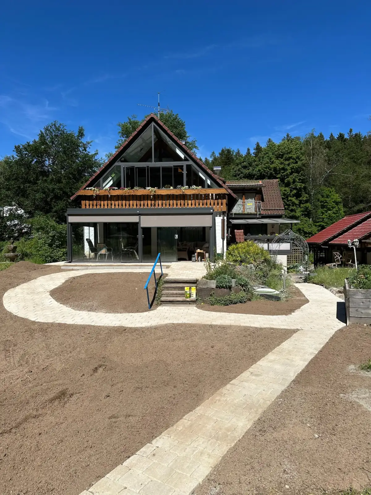 Heller Pflasterweg vor einem Wohnhaus